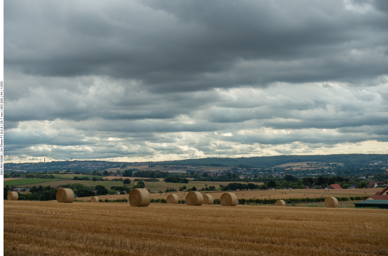 Abgeerntete Felder vor der Hügellandschaft