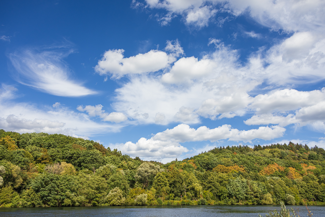 Wolkenformation über bewaldetem Hügel